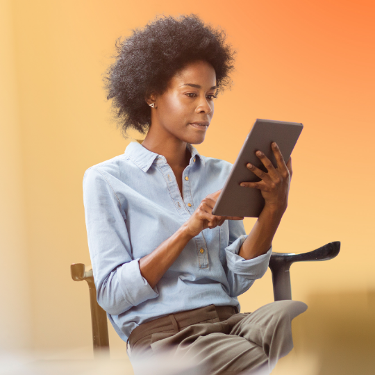 A woman is working on her tablet.