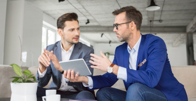 Two men are talking to each other in an office.