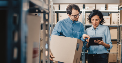 A man and a woman are talking in a storehouse.